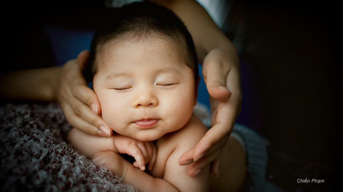 Asian baby sleeping in mother's hands